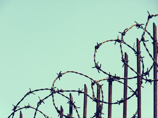 Barbed wires on iron fences to prevent thieves from entering home. Dangerous sharp and obstacles. Border fence boundaries. Restriction zone.