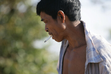 South asian indigenous rural person smoking cigarette in outdoor spaces, No tobacco day conceptual image