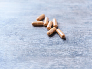 Korean Ginseng capsules. Concept for a healthy dietary supplementation. Wooden background. Soft focus. Close up.