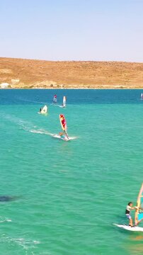 Vertical video of windsurfers - high quality aerial shot with drone of surfers windsurfing on Izmir beach in Aegean Sea Turkey Izmir