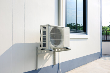 Condenser unit or compressor outside home or residential building. Unit of central air conditioner...
