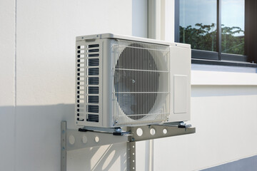 Condenser unit or compressor outside home or residential building. Unit of central air conditioner...