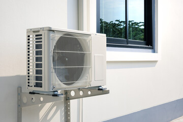 Condenser unit or compressor outside home or residential building. Unit of central air conditioner...