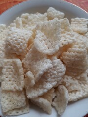 Close up of crispy rice crackers on a white bowl