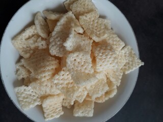 Close up of crispy rice crackers on a white bowl