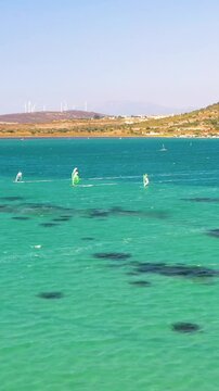 Vertical video of windsurfers - high quality aerial shot with drone of surfers windsurfing on Izmir beach in Aegean Sea Turkey Izmir