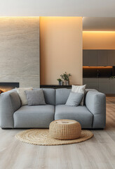 Modern living room with cozy gray sofa and round natural fiber ottoman in a bright apartment