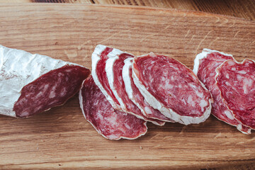 slices of traditional Spanish sausage salami fuet or dry sausage, covered with fermented mold on a...