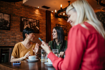 Happy young people enjoy coffee and chat, gathering in a relaxed and social environment.