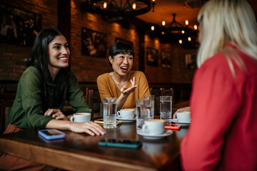 A group of friends catch up over coffee in a cozy cafe, taking a break from their busy lives to...