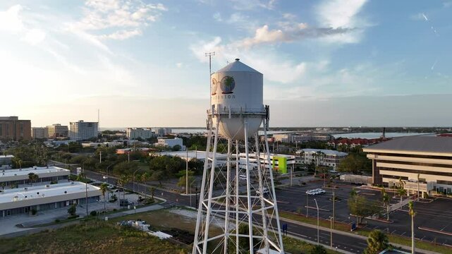 aerial orbit of the water tower in Bradenton, Florida during golden hour with the surrounding city and Manatee River in the background
