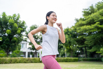 Asian beautiful sportswoman doing running exercise alone in the garden.