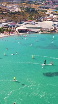 Vertical video of windsurfers - high quality aerial shot with drone of surfers windsurfing on Izmir beach in Aegean Sea Turkey Izmir