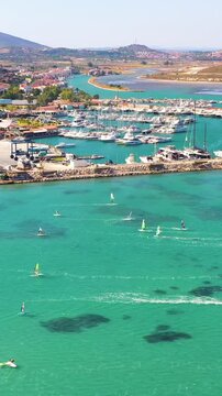 Vertical video of windsurfers - high quality aerial shot with drone of surfers windsurfing on Izmir beach in Aegean Sea Turkey Izmir