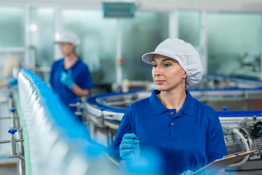 Caucasian female industry worker team working in factory warehouse.