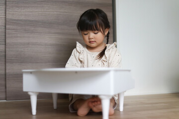 小さなピアノを弾く女の子