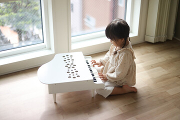 小さなピアノを弾く女の子