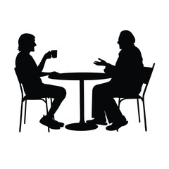 Two men sitting at a table. One man is drinking coffee. The other man is talking. There are two chairs