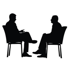 Two men are sitting in chairs and talking. One of the men is wearing a tie. The chairs are black