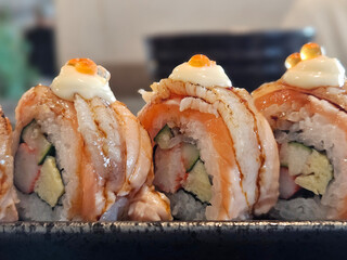 Salmon and Engawa Japanese maki rolled serving on the black plate.