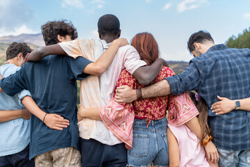 Young diverse friends embracing in nature showing multicultural community friendship youth...