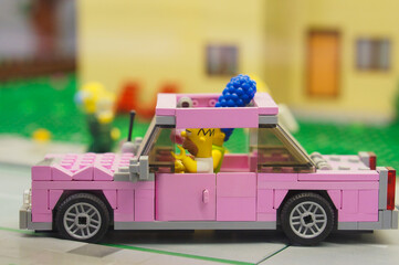 Naklejka premium Close-up shot of Lego Simpsons figures sitting in a pink toy car