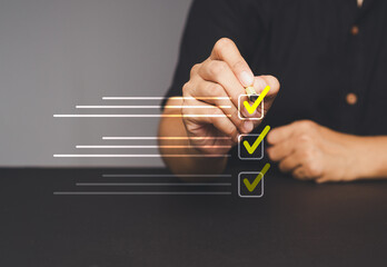 Hand checking boxes on a virtual to-do list, yellow checkmarks on a transparent digital interface
