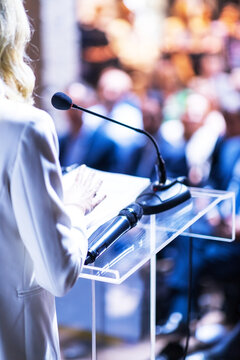 Female public speaker at business conference, corporate presentation, workshop, coaching training, news conference, company meeting, public or political event. Public speaking concept.
