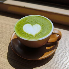 Creamy artsy matcha latte in ceramic cup