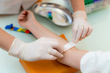 Doctors bandaging child's arm post-treatment. A medical professional is applying a bandage to a...