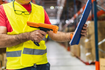 Warehouse worker scanning and checking inventory with barcode scanner