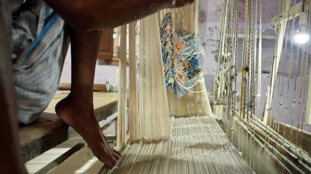 Close-up of an artisan's hands skillfully weaving threads on a traditional loom, producing intricate patterns for a Banarasi silk saree in a rustic workshop. Perfect for showcasing craftsmanship.