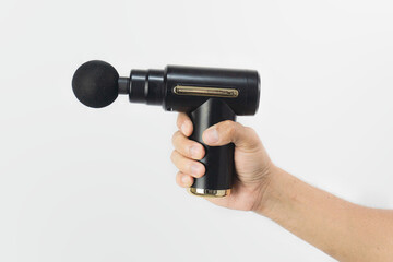 hand holding a black massage gun in white isolated background. Massage gun for healthy lifestyle.
