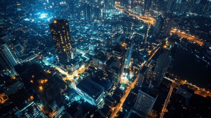 Obraz premium Aerial Night View of a Vibrant Urban Skyline Illuminated by City Lights Showcasing Modern Architecture and Lively Streets in a Bustling Metropolis