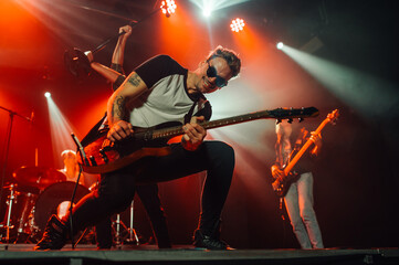 Guitarist performing energetically on stage during rock concert