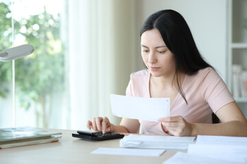 Asian woman calculating expenses checking bill
