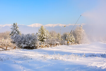 Obraz premium Winter forest, wooden fence, mountain peaks