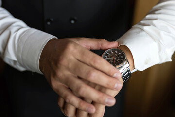 hands of a man in a white shirt with a watch