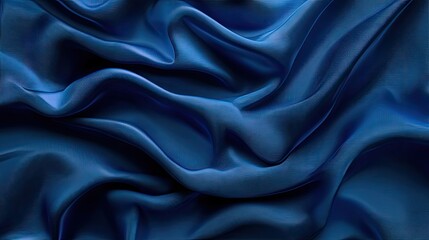Fototapeta premium Rich blue satin fabric draped elegantly, showcasing its soft texture and luxurious sheen.