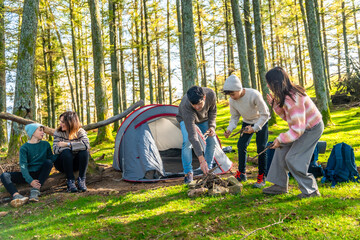 Family preparing campfire in front of the tent
