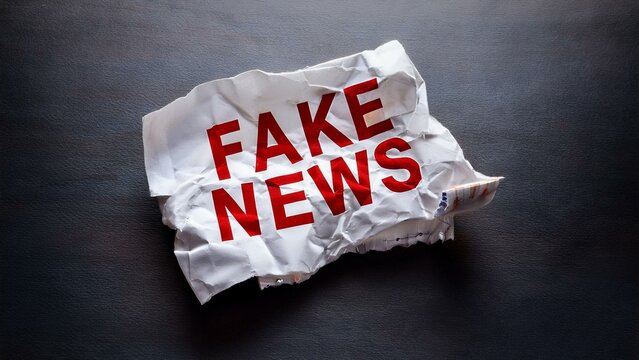 Crumpled paper with bold red font symbolizing fake news from a high angle perspective  
