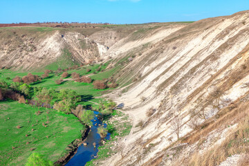 Landscape of river Reut in Furceni village from Moldova. Serene river meanders through a lush green valley, surrounded by gentle hills. Landscape with chalk cliff, green valley and small river