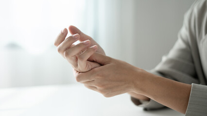 Woman hand with wrist pain numbness and pain in the palm of the hand has pain and tingling in the nerve endings This is a side effect of sitting and working for a long time on a laptop at the office