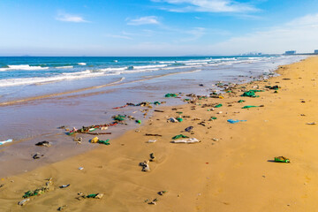 Catastrophic scale of plastic pollution in tropical seas. Many lot of trash on the beach, plastic cups, bags nets fishing in the picturesque Asia landscape around