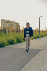 Fototapeta premium A man in a blue jacket and khaki pants walks down a sidewalk