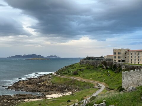 Stone walls and buildings of the Monterreal Castle on the coast of Atlantic Ocean with C&iacute;es Islands, Baiona, Galicia, Spain, January 2024