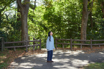 Fototapeta premium 秋の公園で楽しく遊んでいる小学生の女の子の様子
