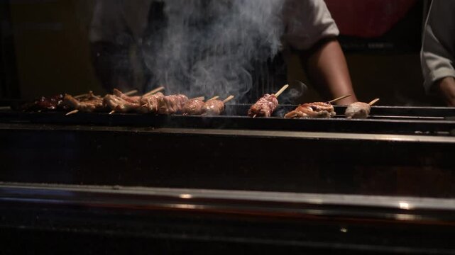 Japanese food yakitori chicken skewers izakaya chef cooking with charcoal fire 4k