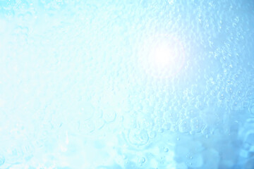 Bubbles and seething water in the light of sunlight.Blue water texture.