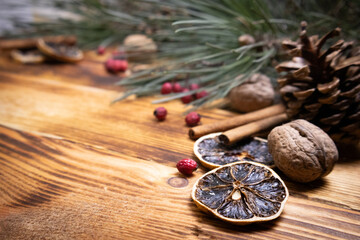 Christmas wood background Dried orange cinnamon sticks red berries fir tree branches nuts